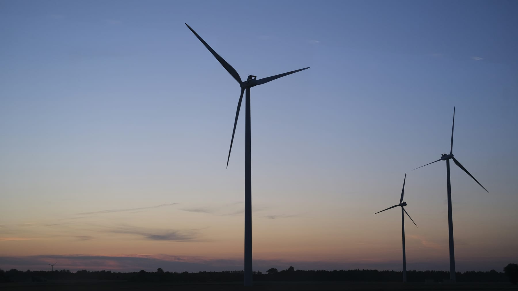 Three wind turbines silhouetted at dusk